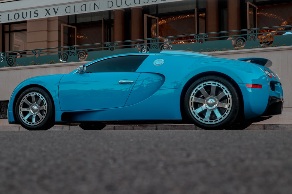 a blue sports car parked in front of a building