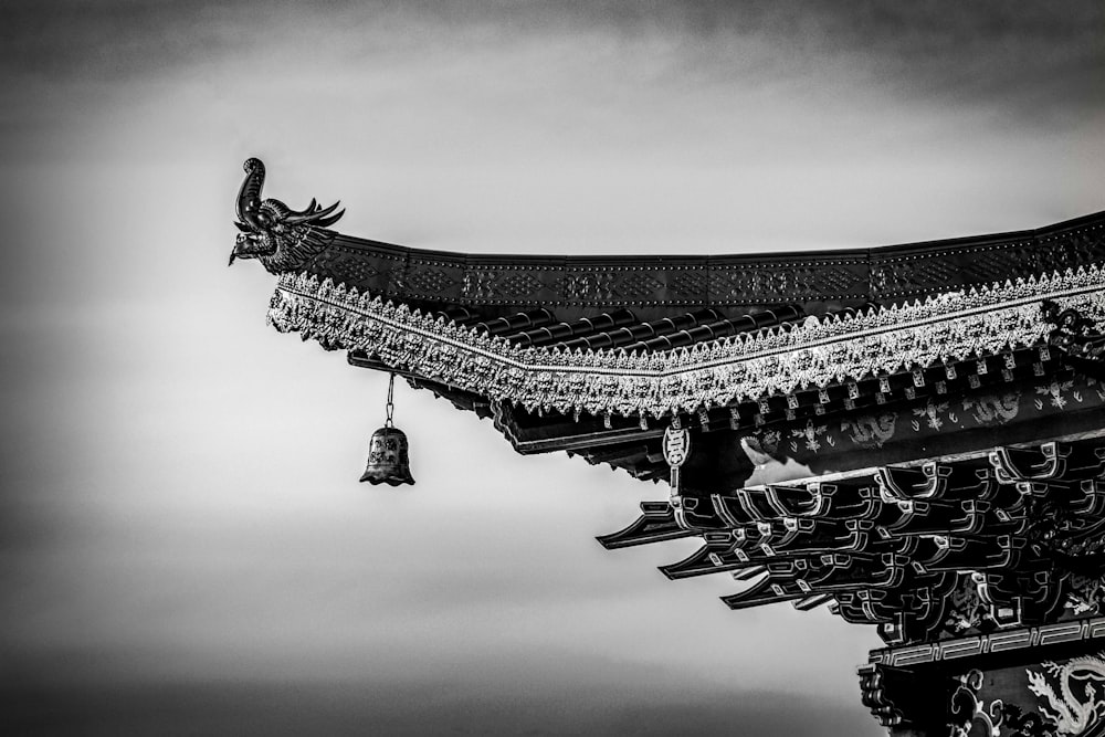 a black and white photo of a building with a bell