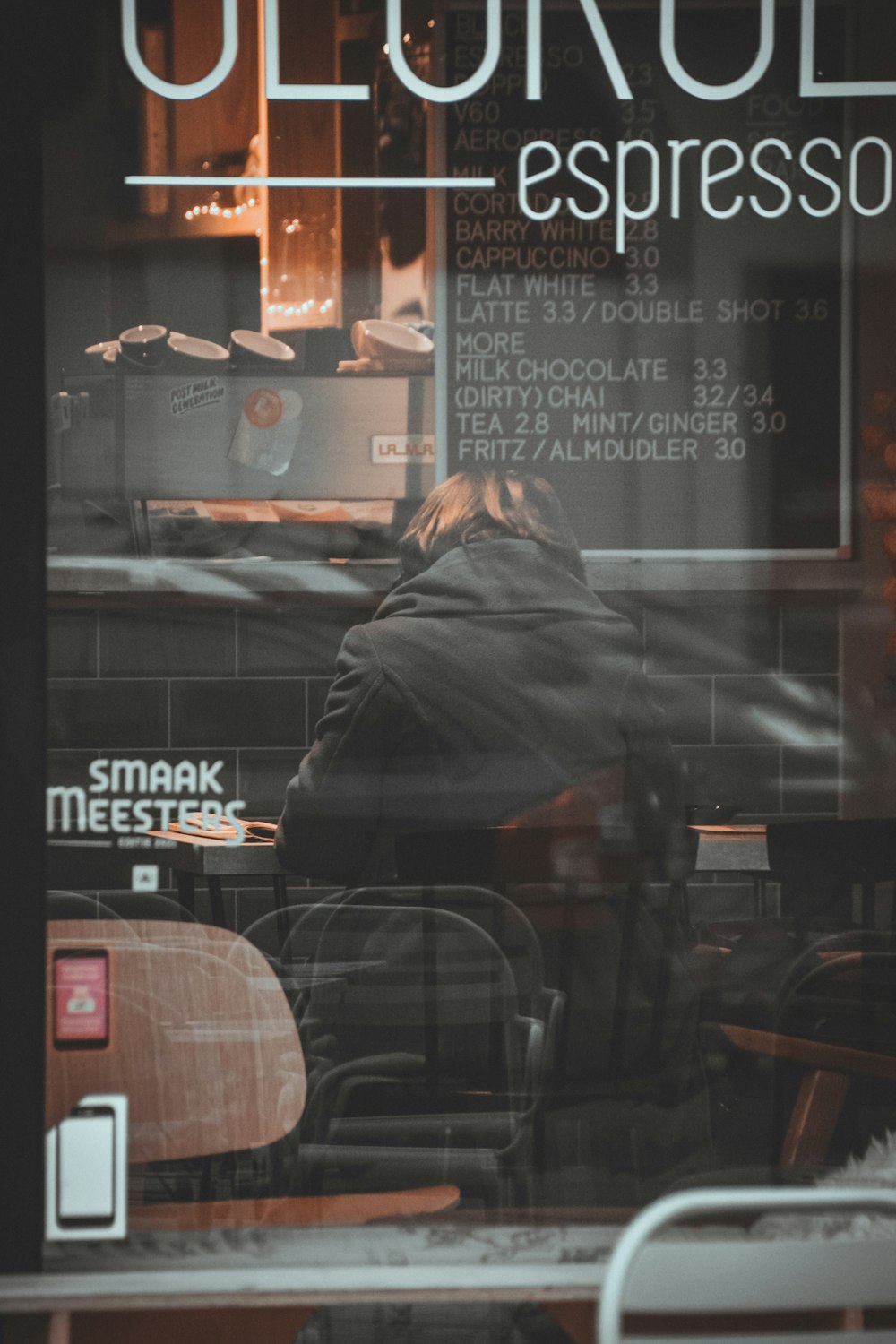 a person sitting at a table in front of a window