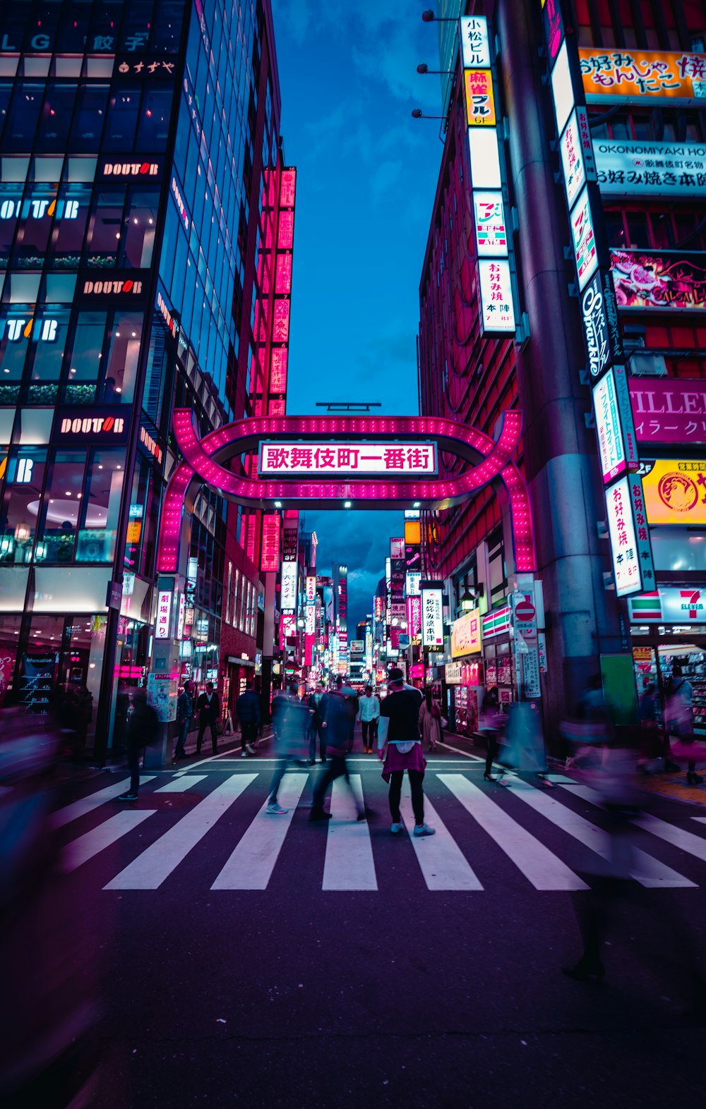 a group of people crossing a street at night