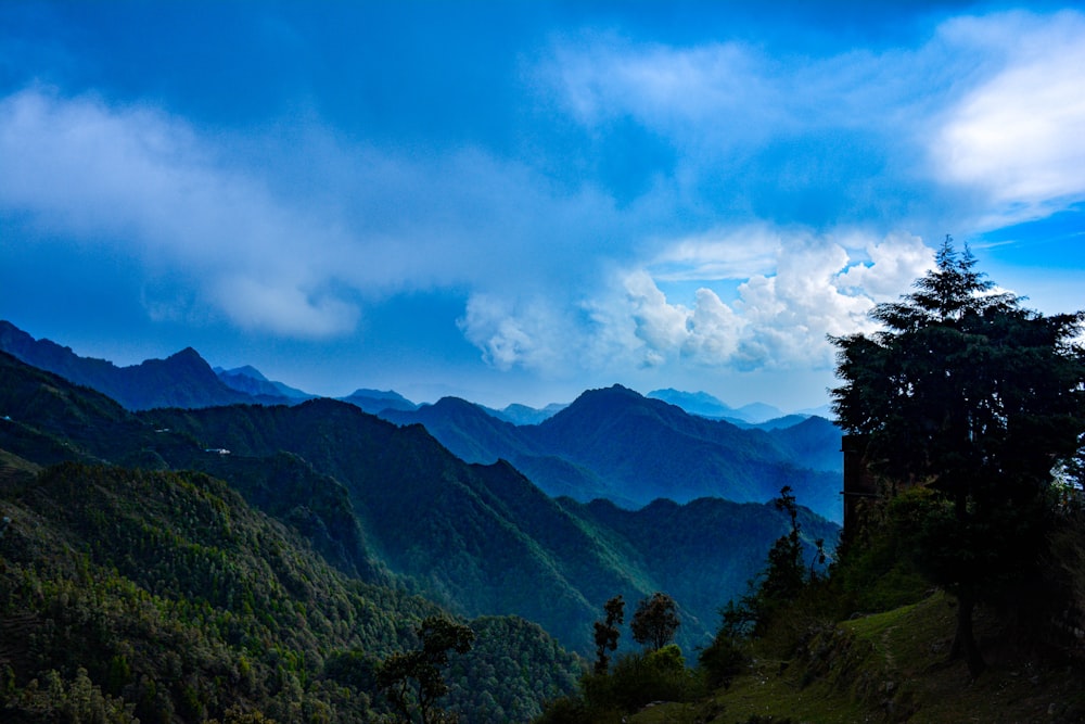 a view of a mountain range with trees and mountains in the background