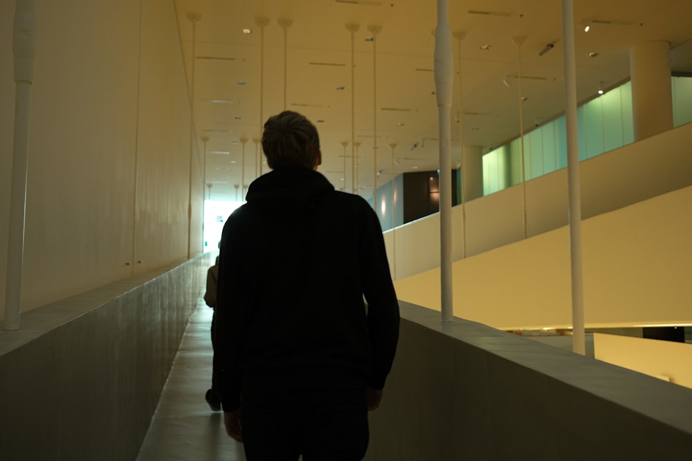 a man walking down a hallway in a building