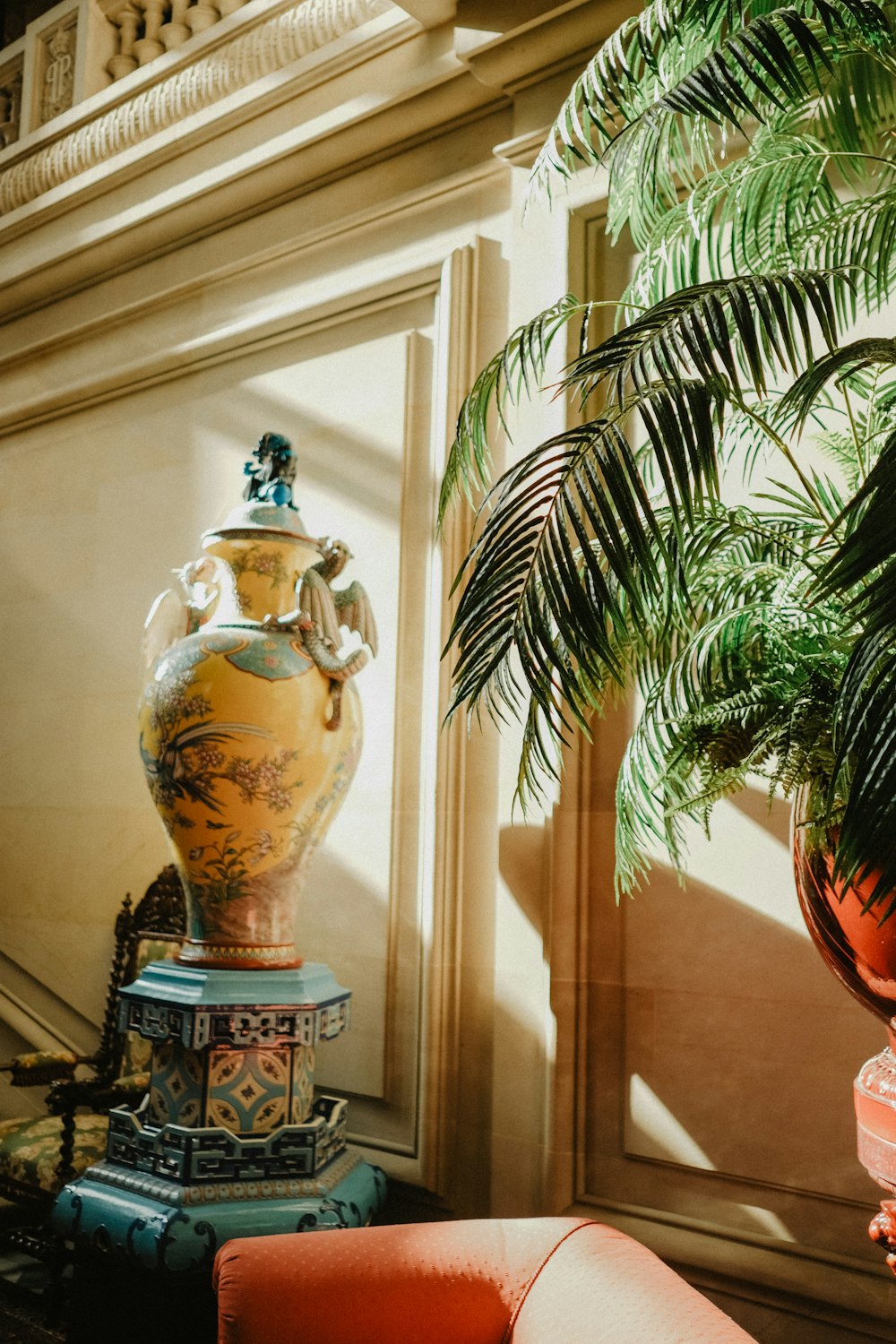 a large vase sitting on top of a table next to a plant