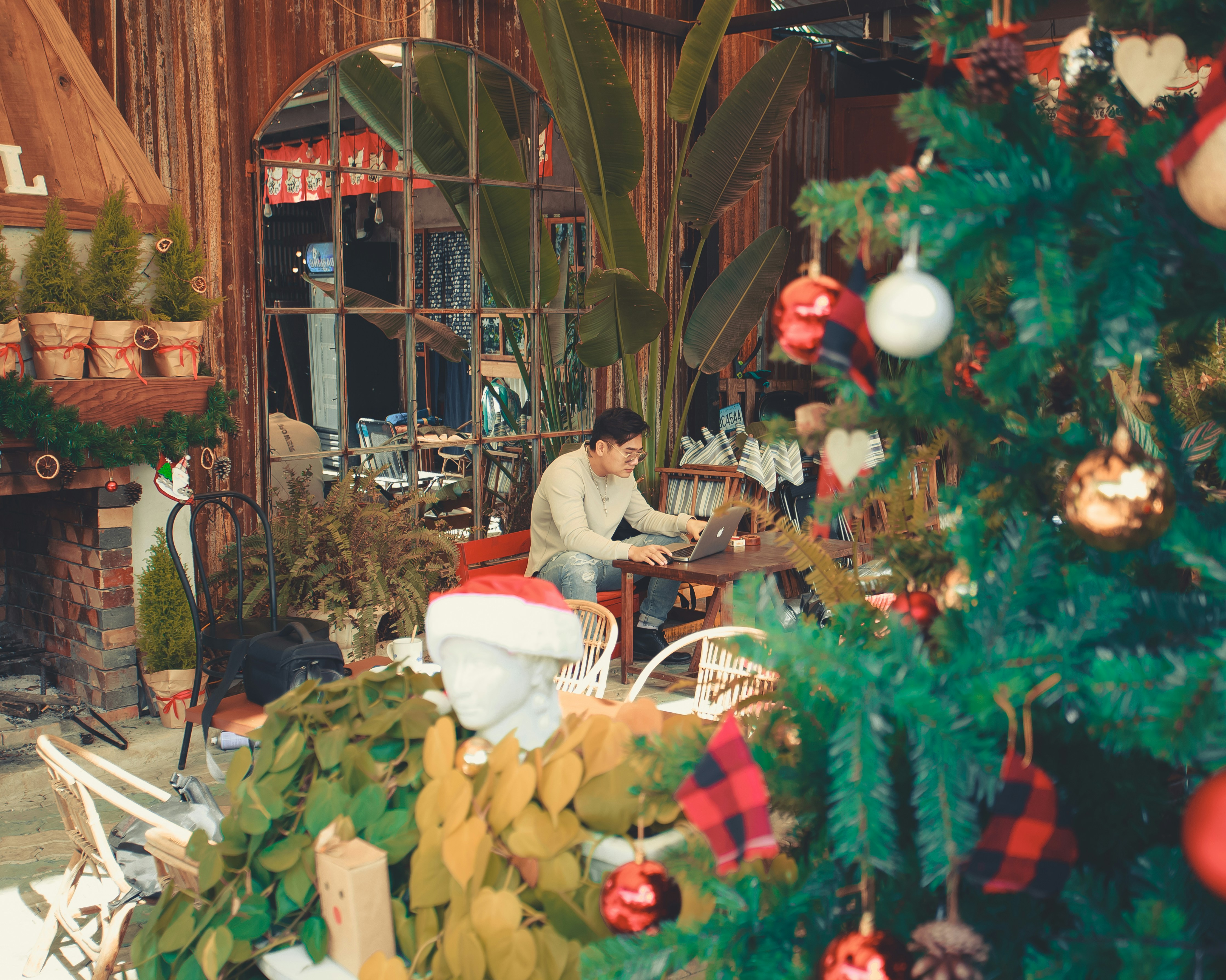a man sitting at a table in front of a christmas tree