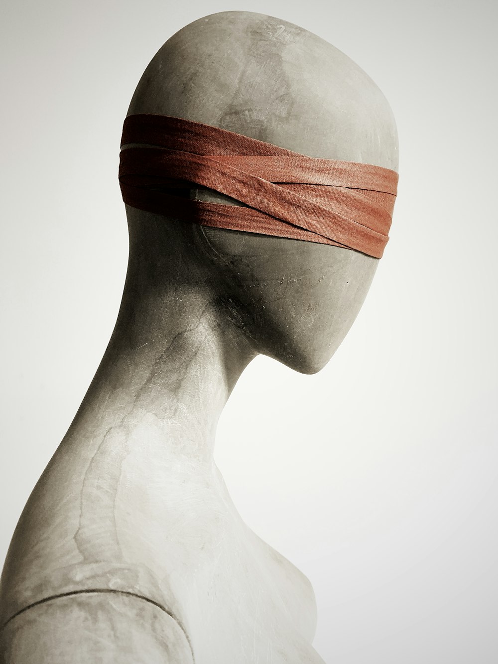 a white mannequin with a red band on its head