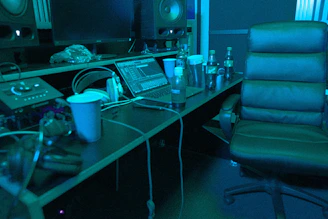 A cozy studio corner with headphones, mixing console, and a coffee mug glowing under soft light.