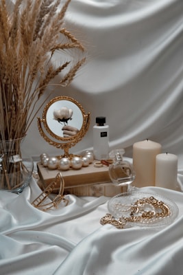 a table topped with a mirror and a vase filled with flowers