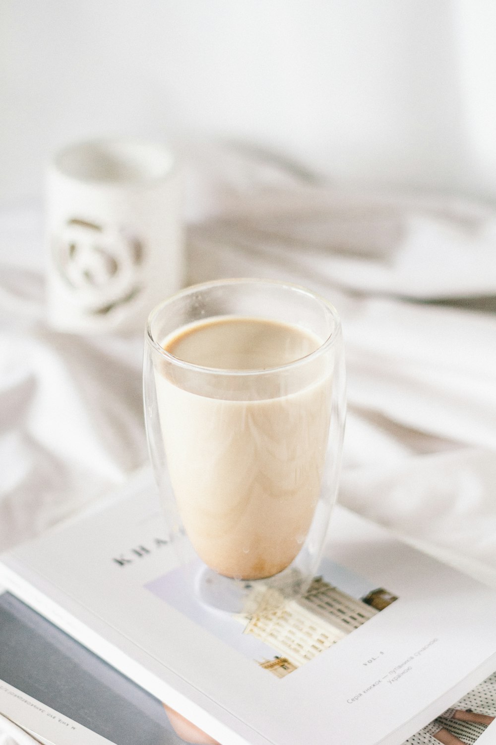 a cup of coffee sitting on top of a magazine