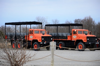 a couple of orange trucks parked next to each other