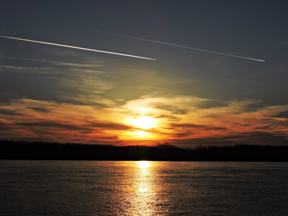 the sun is setting over a body of water