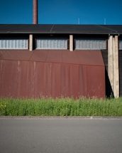 Factory exterior of a small chemical manufacturing plant in Bogor, Indonesia, with red and white accents matching the company logo.