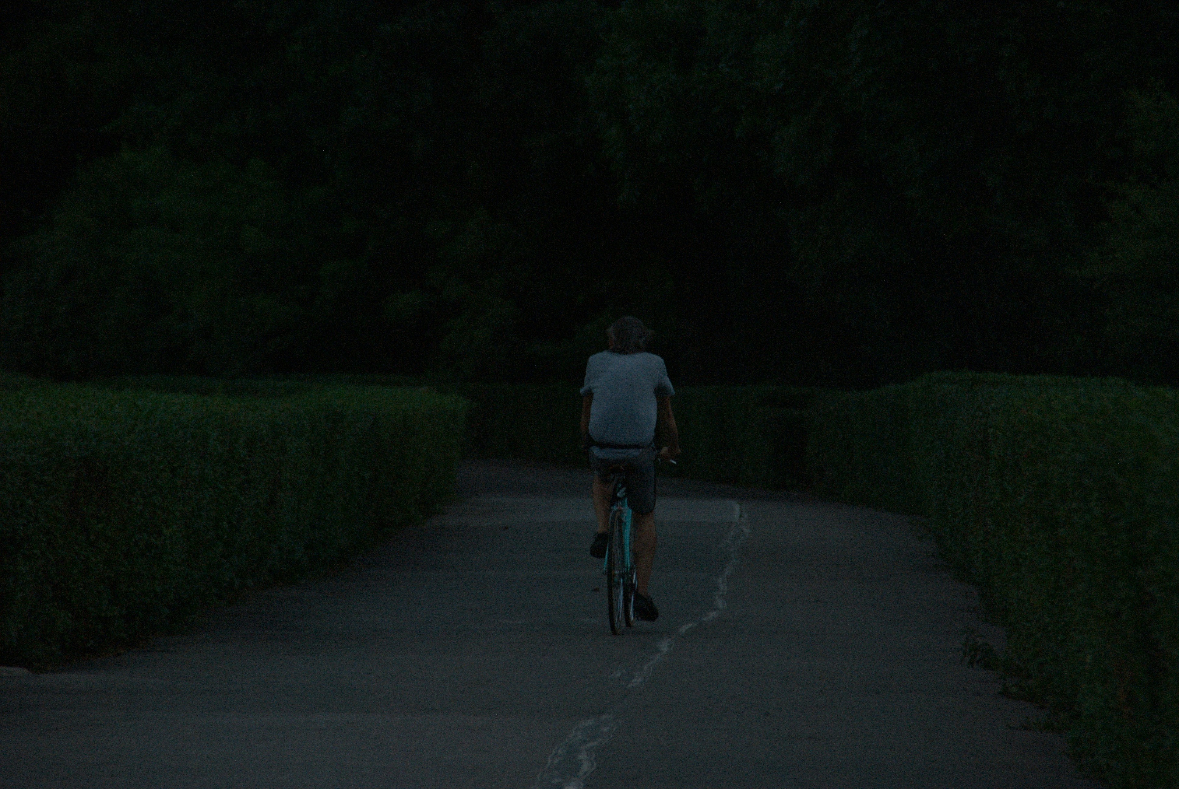 a man riding a bike down a road at night