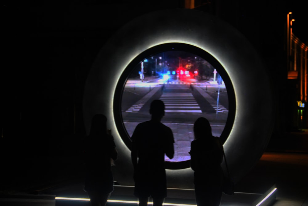 a couple of people that are standing in the dark