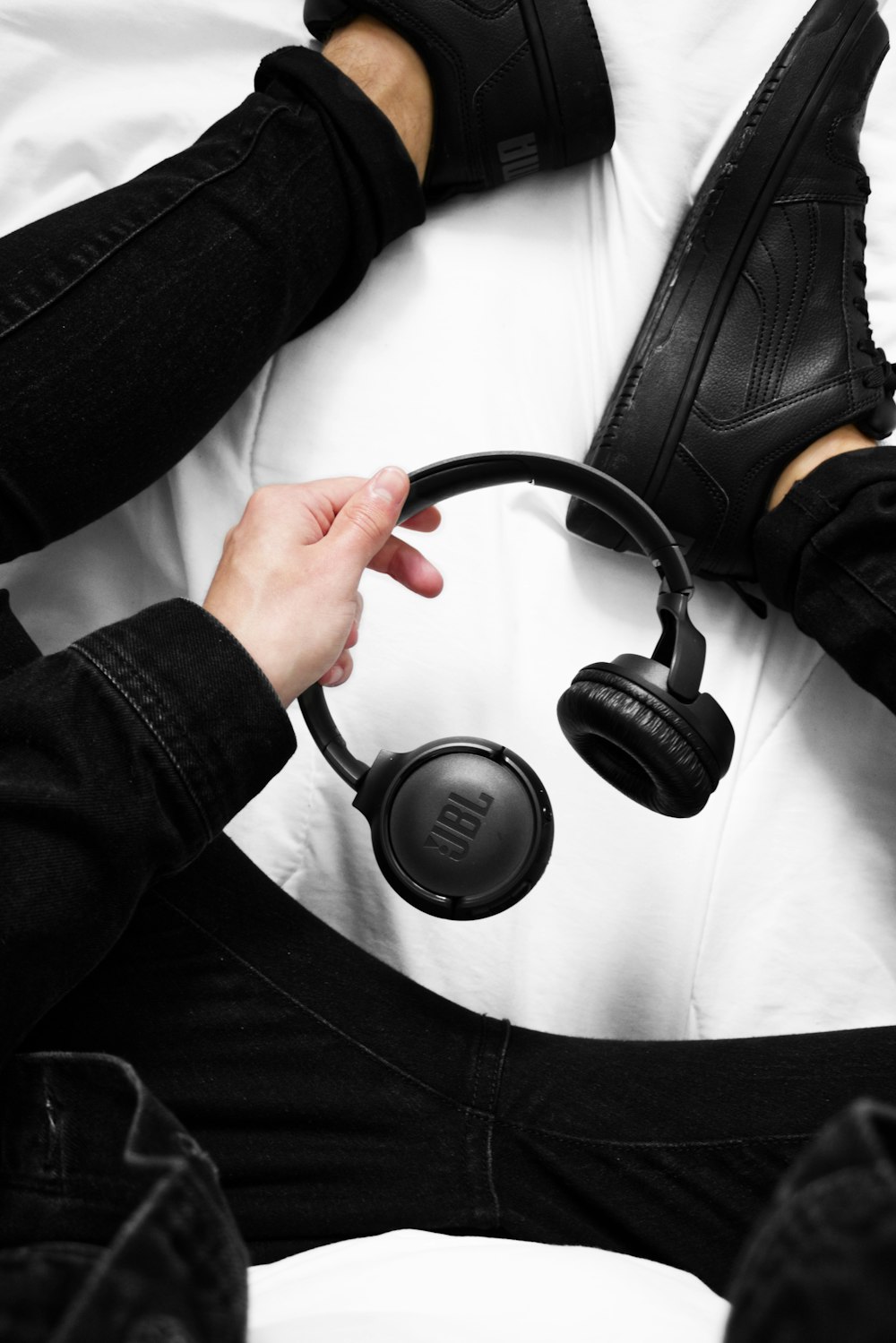 a person wearing headphones sitting on a bed