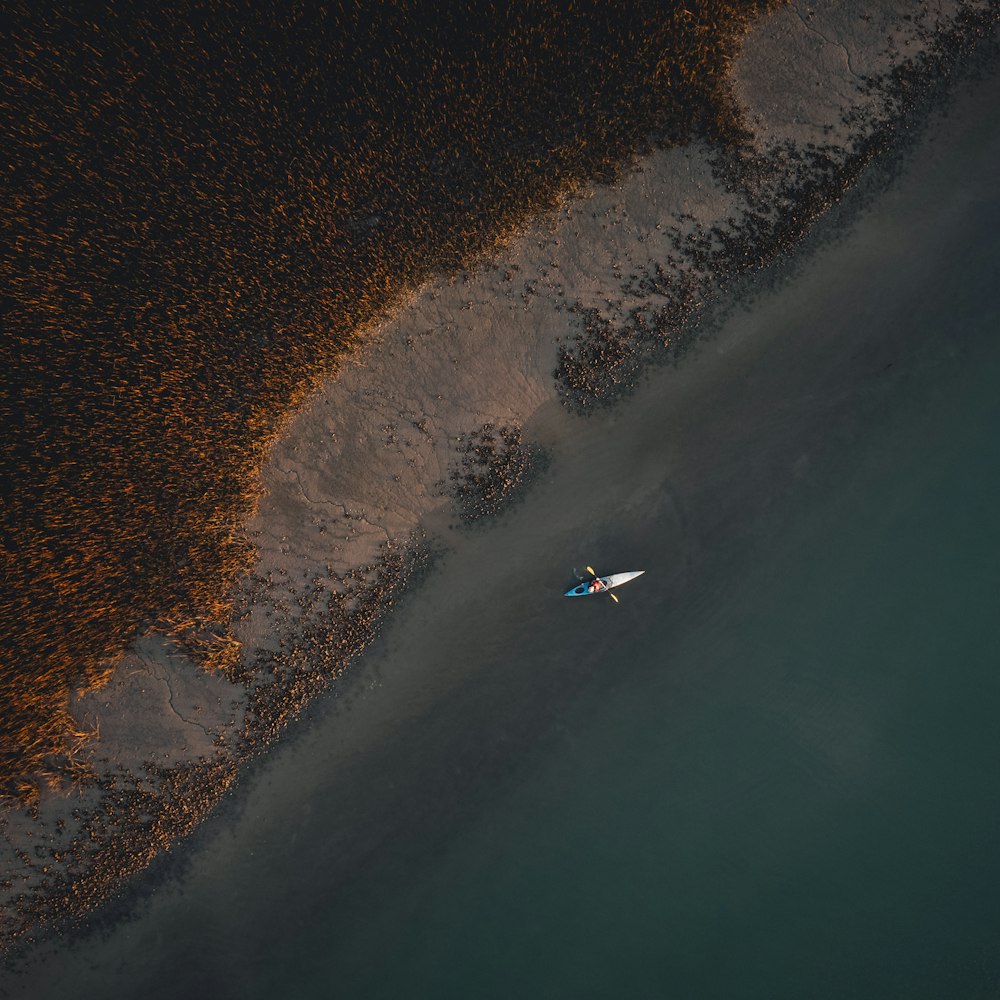 an aerial view of a person on a surfboard in the water