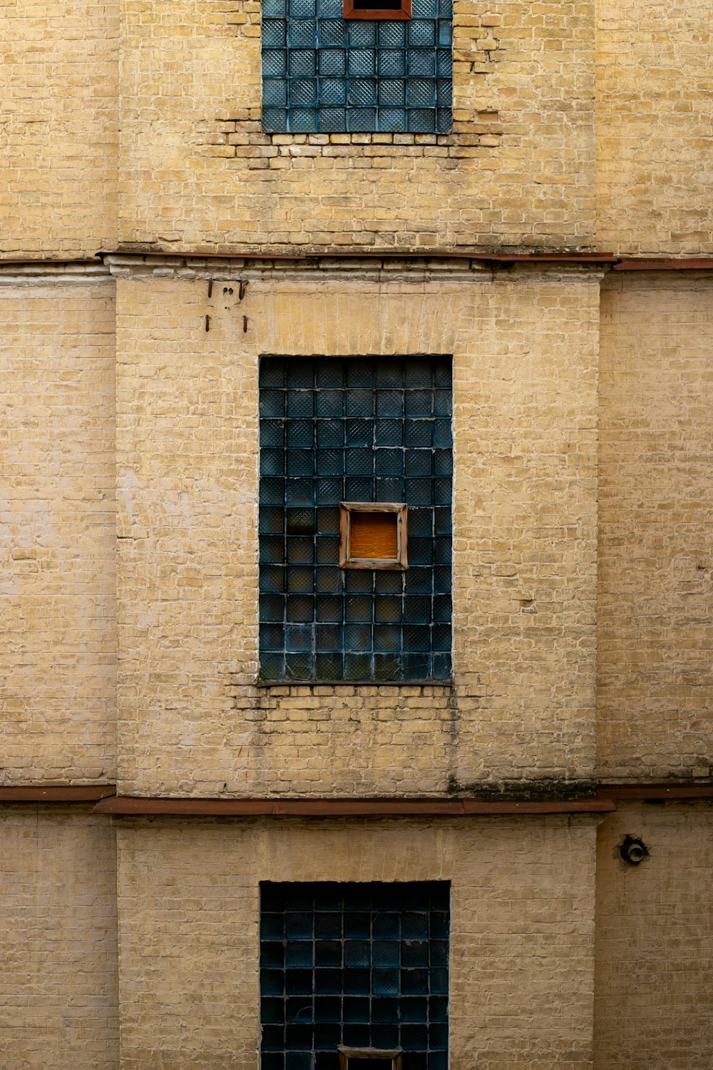 a brick building with two windows and a bench