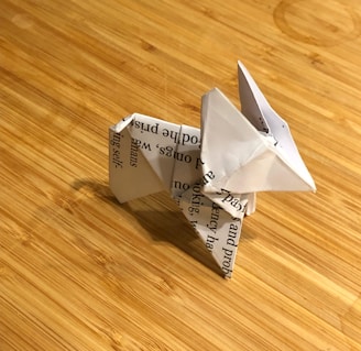 A collection of simple origami animals displayed on a rustic shelf.