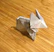 Close-up of delicate paper toy animals arranged on a wooden table.