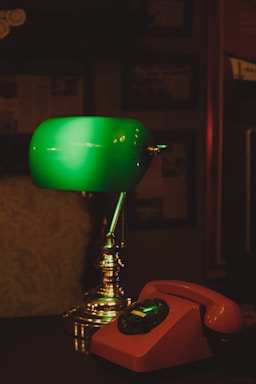 A cozy, dimly lit room with a vintage telephone and soft red lighting.