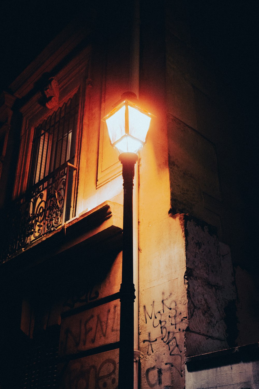 a street light is lit up in front of a building