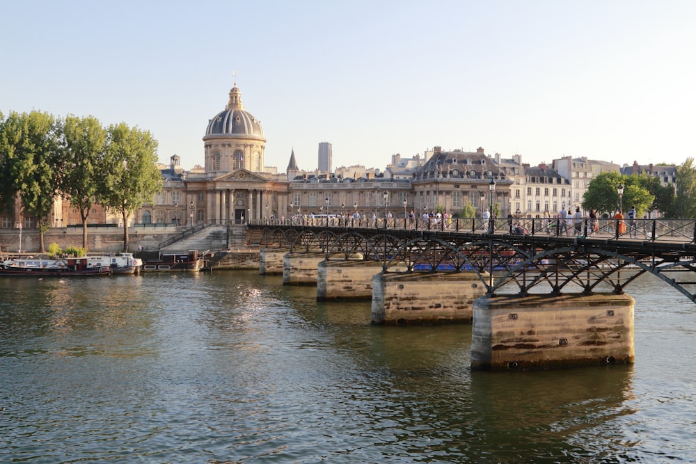 a bridge over a body of water with buildings in the background