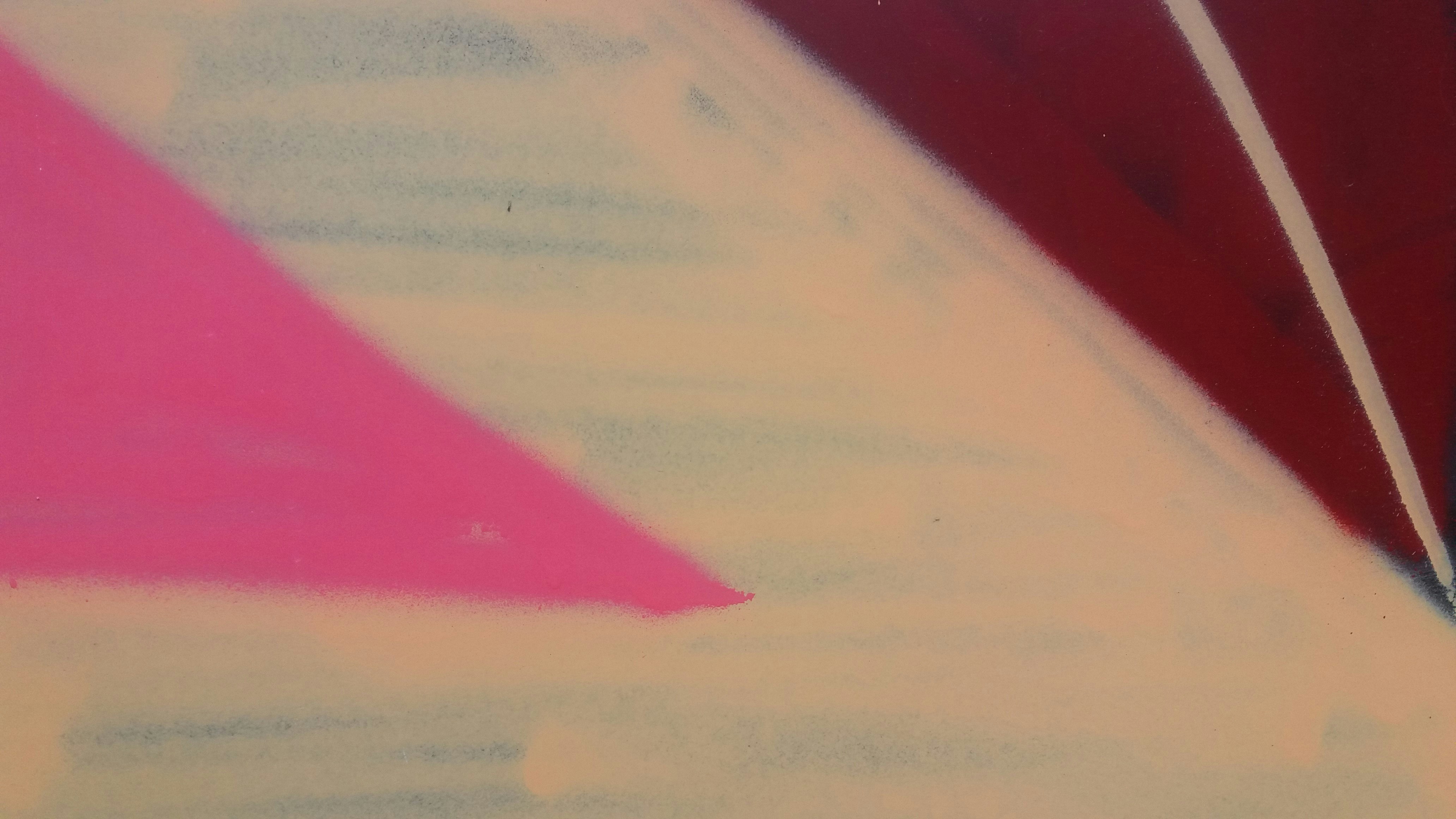 a close up of a piece of paper with a pink triangle on it
