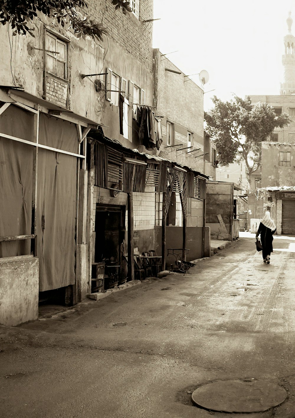 a man walking down a street next to a tall building