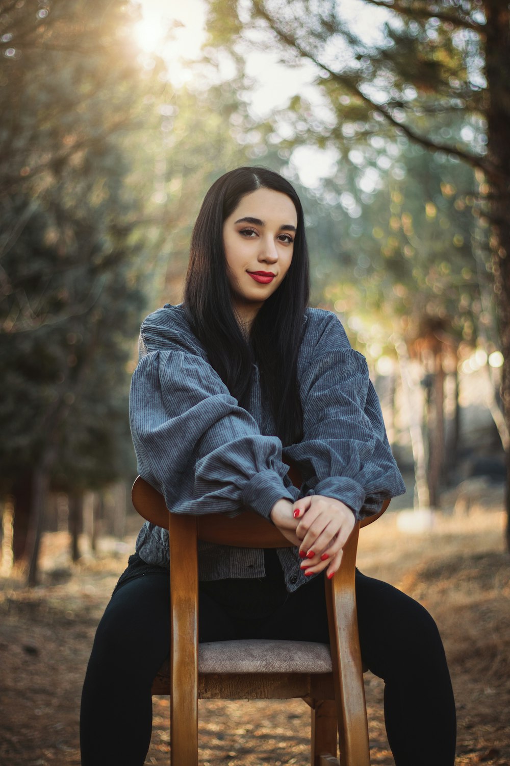 a woman sitting on top of a wooden chair