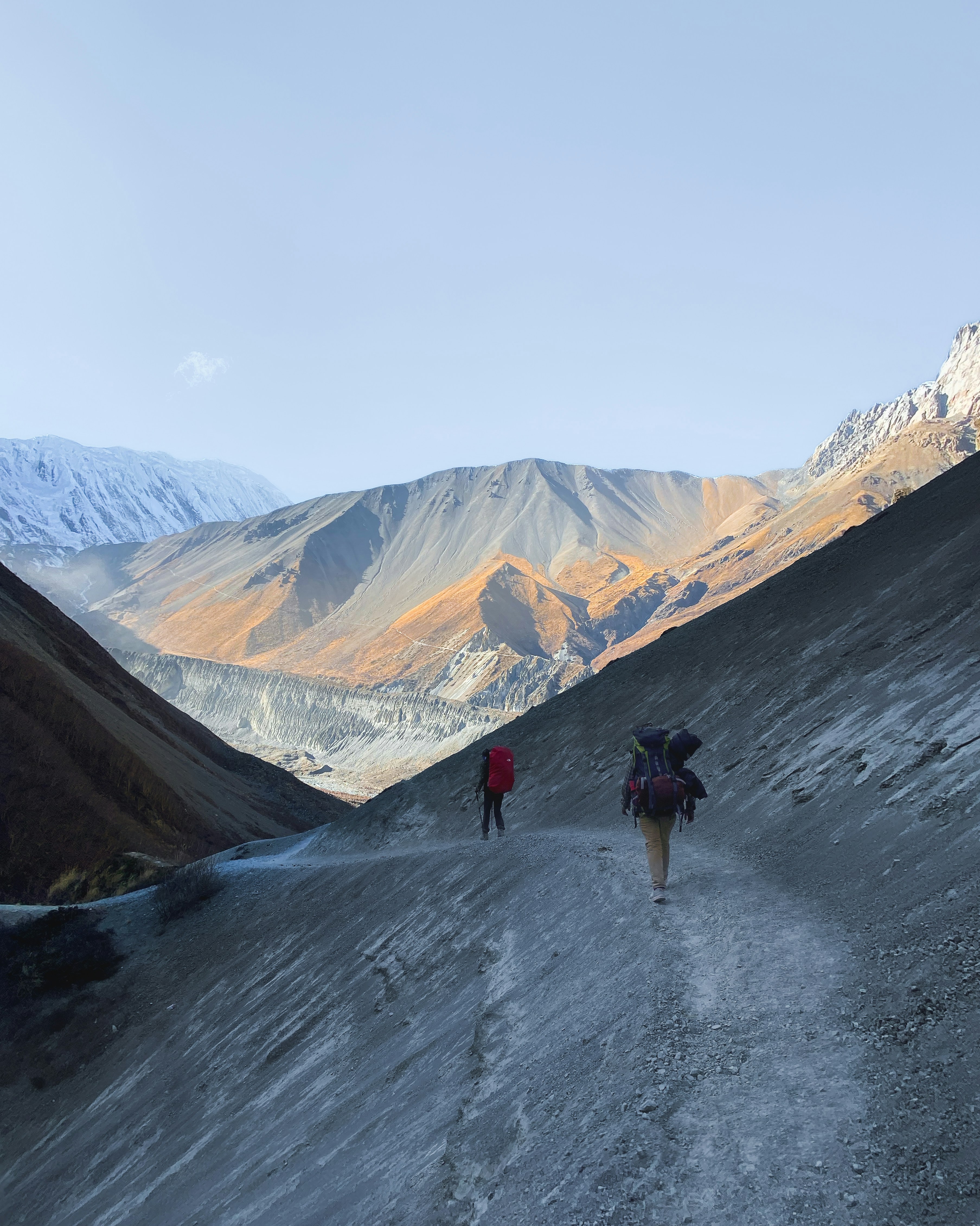 Un par de personas caminando por un camino de tierra