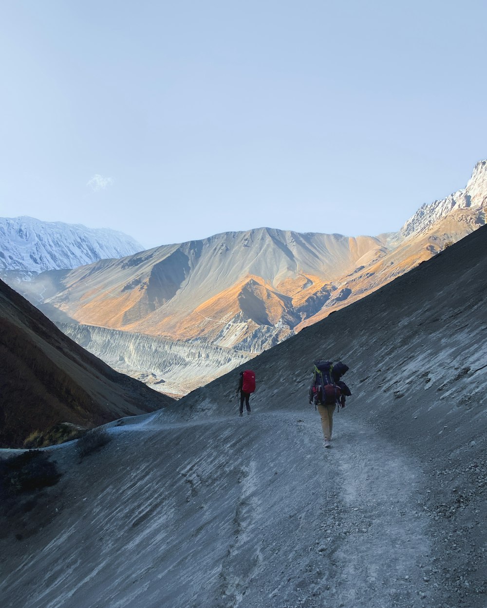 a couple of people walking down a dirt road