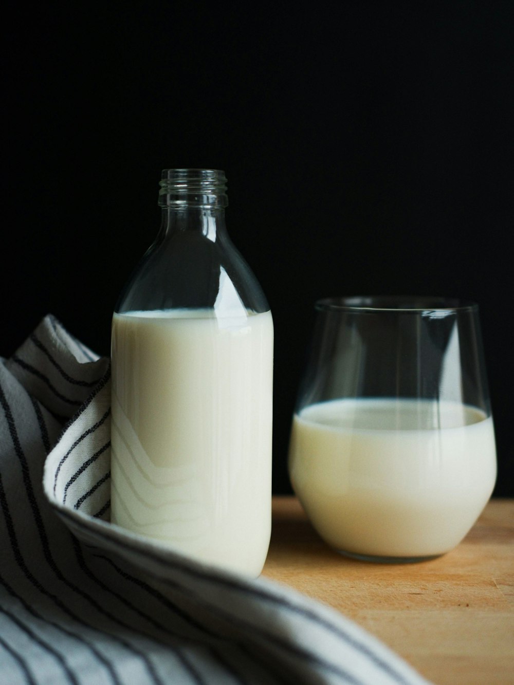 una bottiglia di latte accanto a un bicchiere di latte