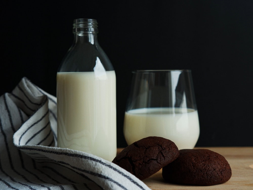 a bottle of milk and two cookies on a table