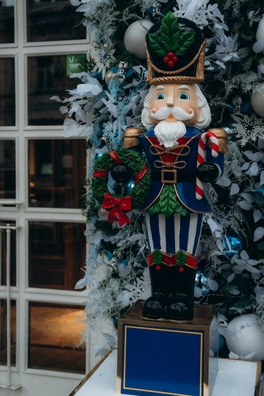 a statue of a nutcracker in front of a christmas tree