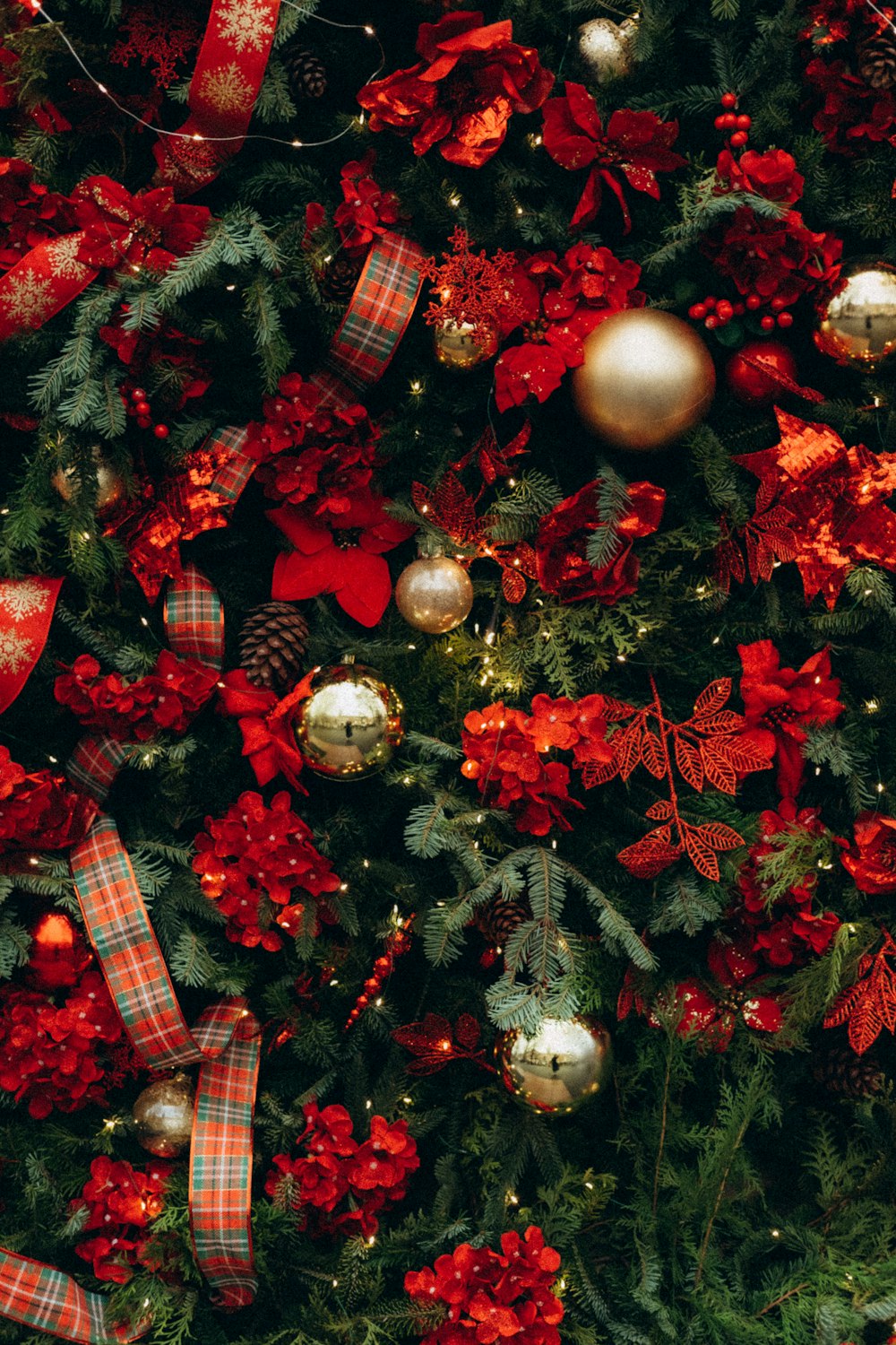 Un árbol de Navidad con adornos rojos y dorados