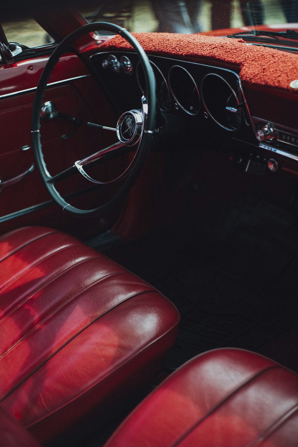 the interior of a classic car with red leather seats