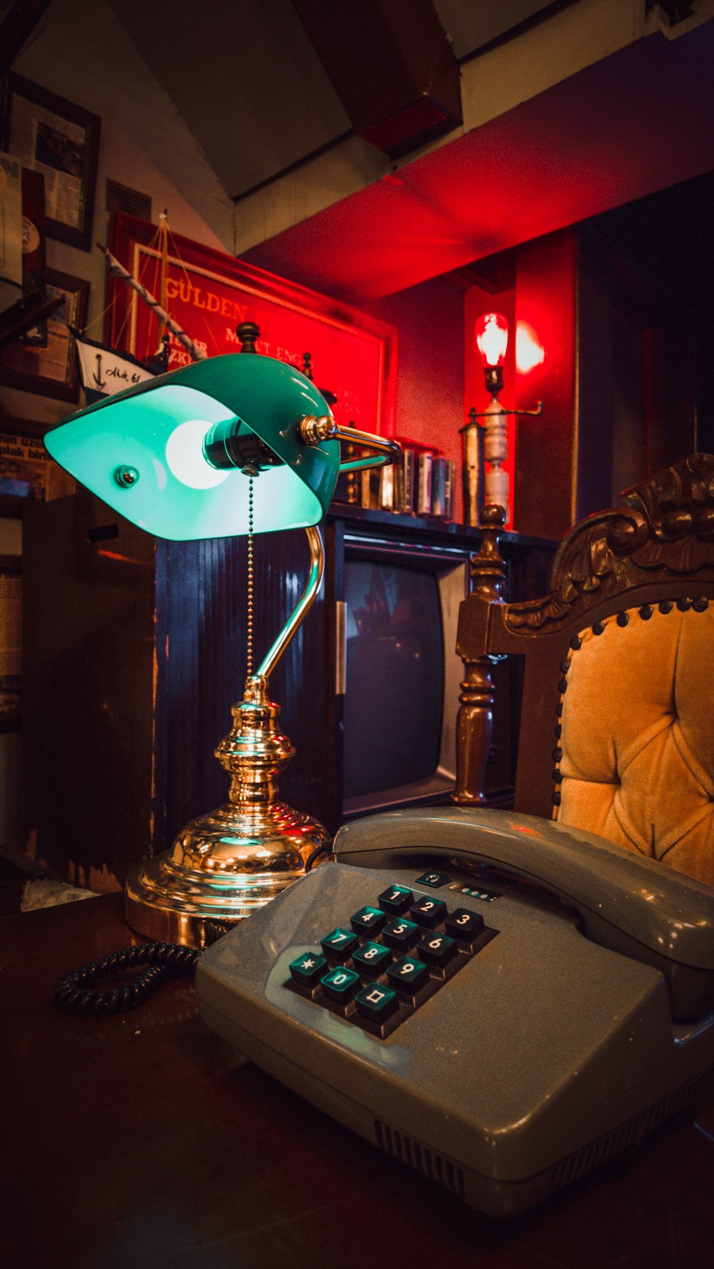 a desk lamp sitting on top of a desk next to a telephone