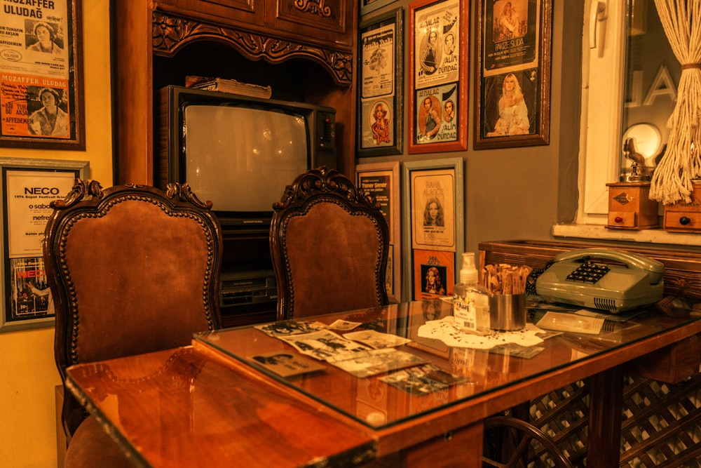 a desk with a phone, telephone, and pictures on the wall