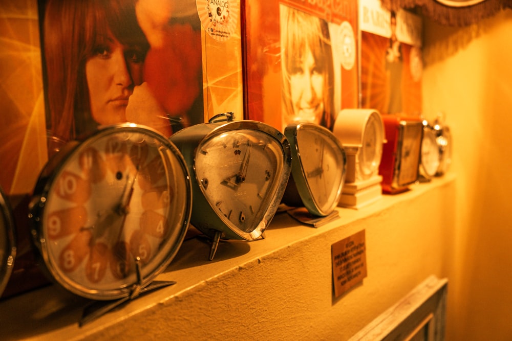 a row of clocks sitting on top of a wall