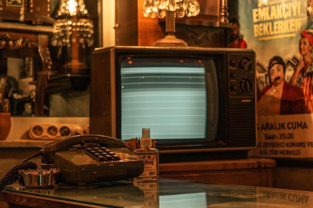 Un telefono vecchio stile seduto sopra un tavolo di vetro