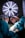 Two surgeons wearing masks and colorful caps are intensely focused on performing surgery under a bright surgical light. They are dressed in teal surgical gowns and white gloves, with a variety of surgical instruments in use.