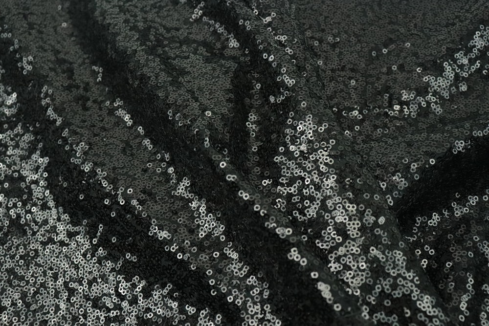 a close up of a black and silver sequin fabric