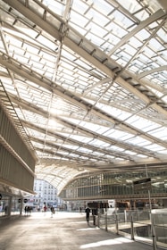 a group of people walking under a glass roof
