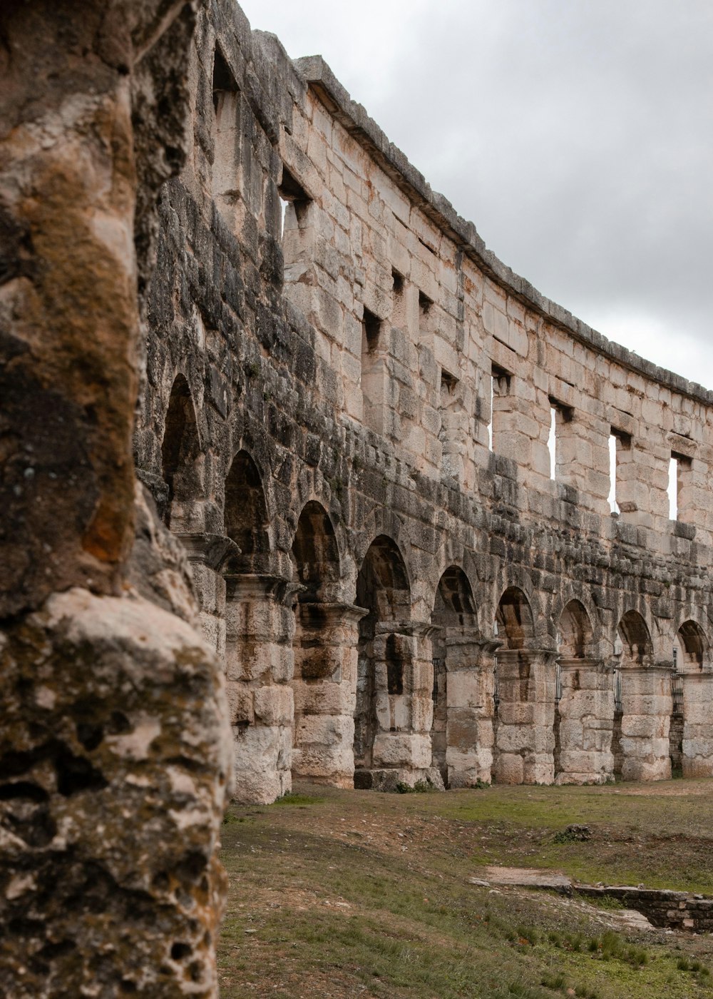 un grande edificio in pietra con un orologio sul lato di esso