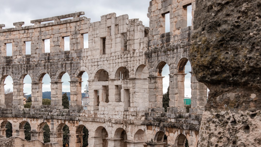 a stone building with many windows and arches,