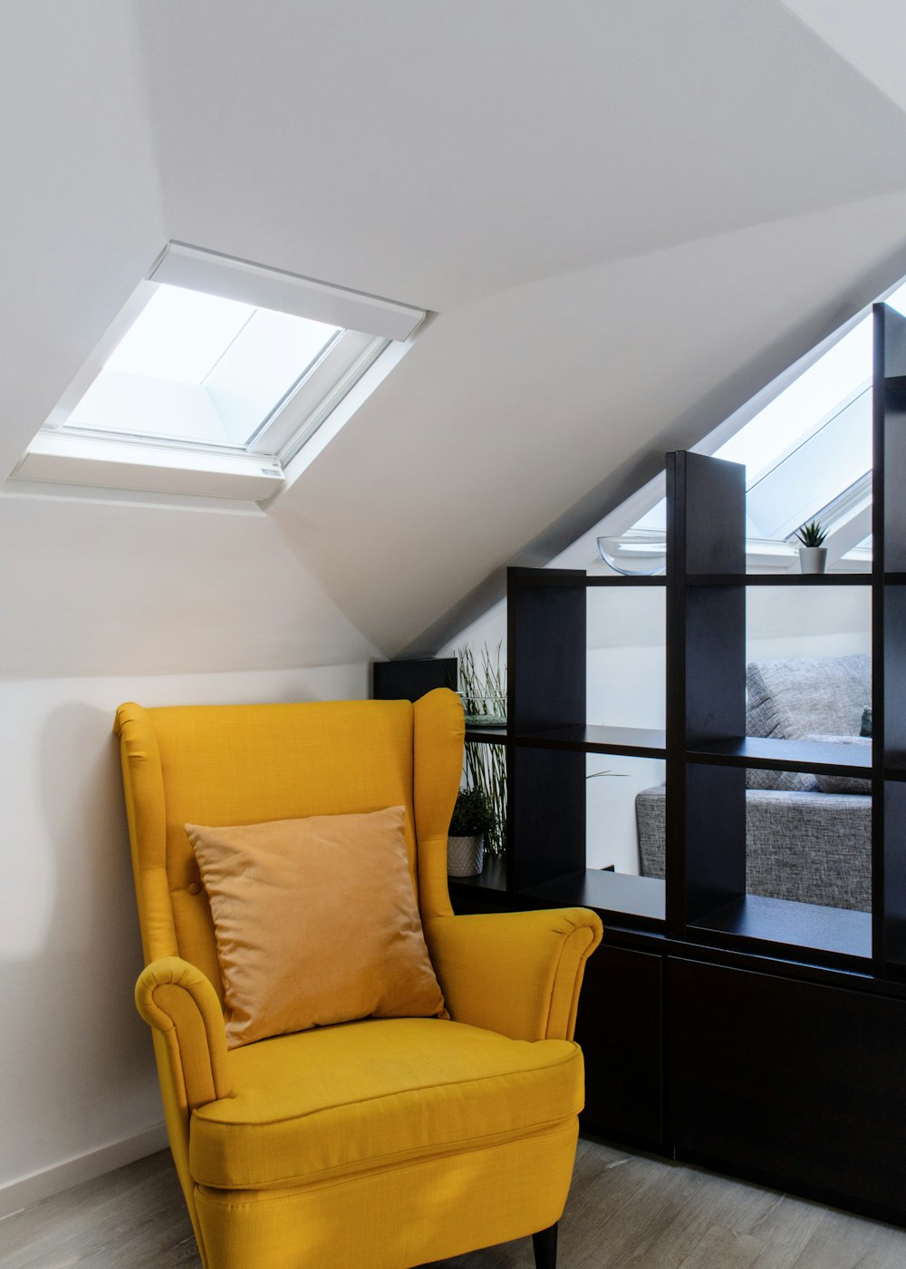 a yellow chair sitting in front of a window