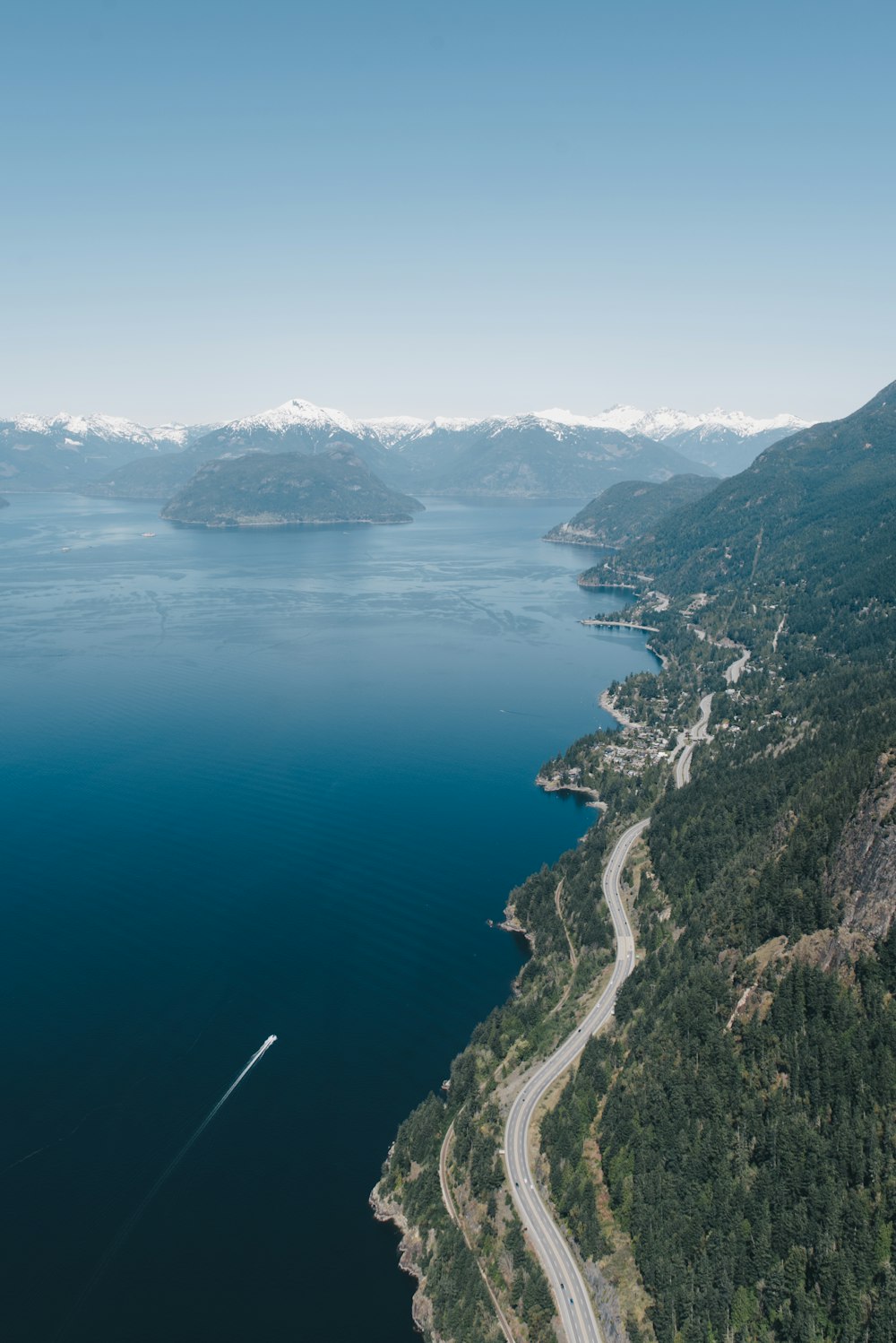 an aerial view of a road and a body of water