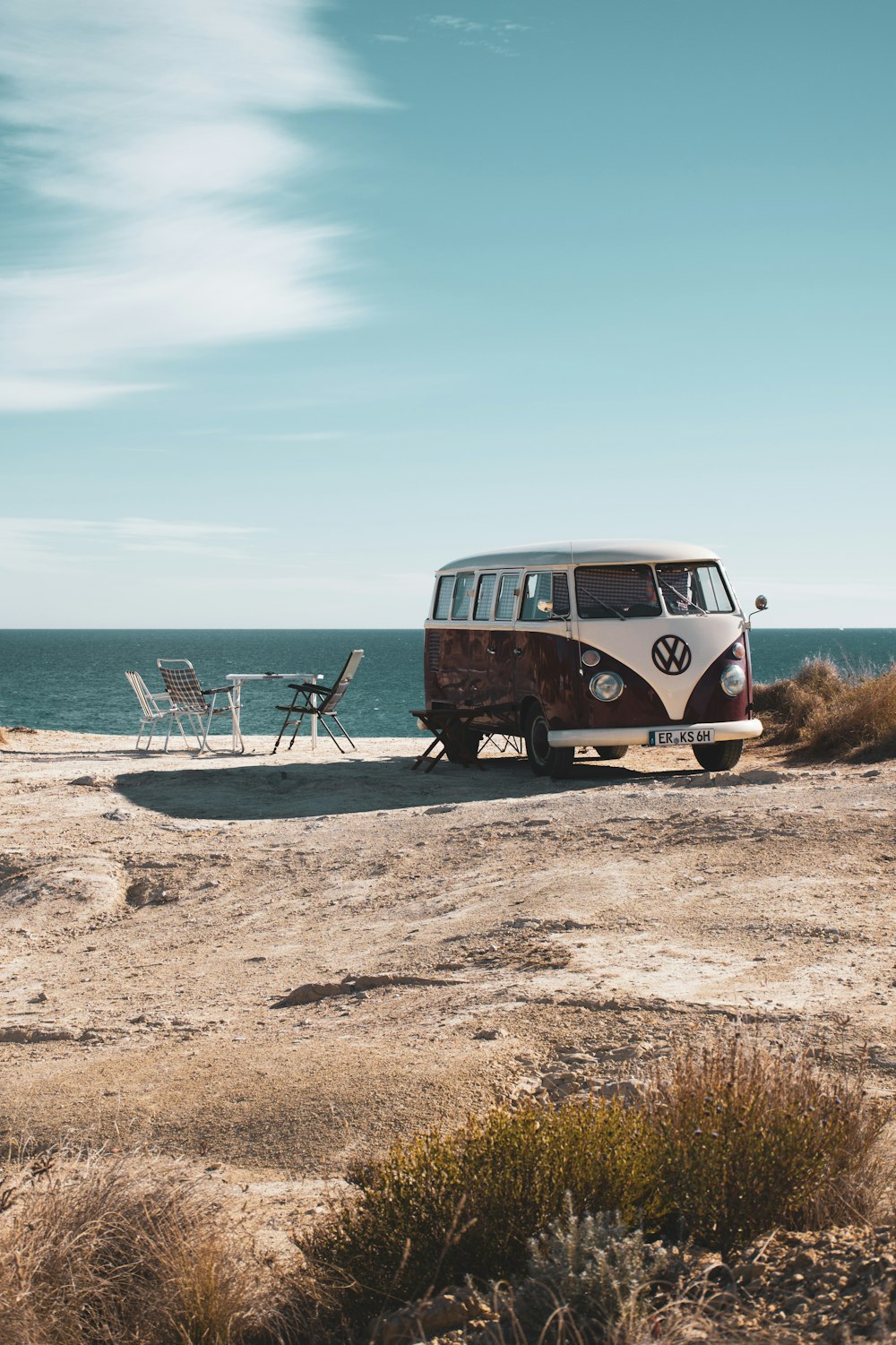 a bus parked on a beach next to the ocean