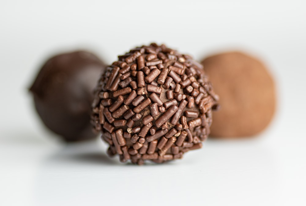 a close up of a chocolate ball on a white surface