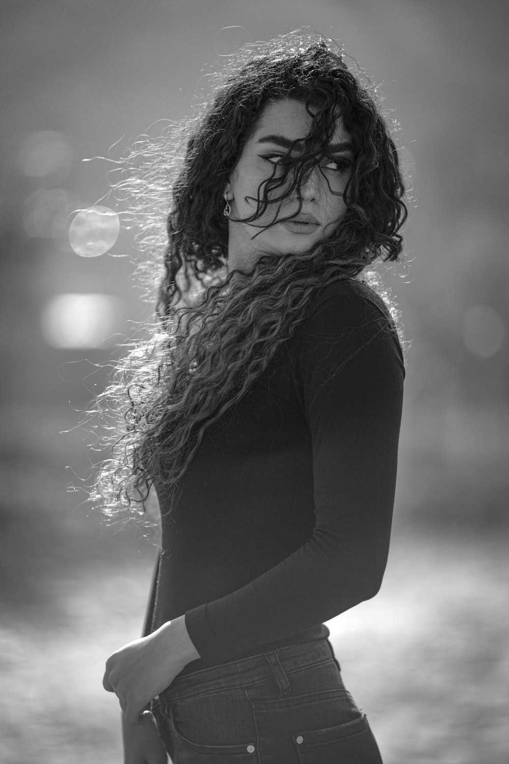 a black and white photo of a woman with curly hair