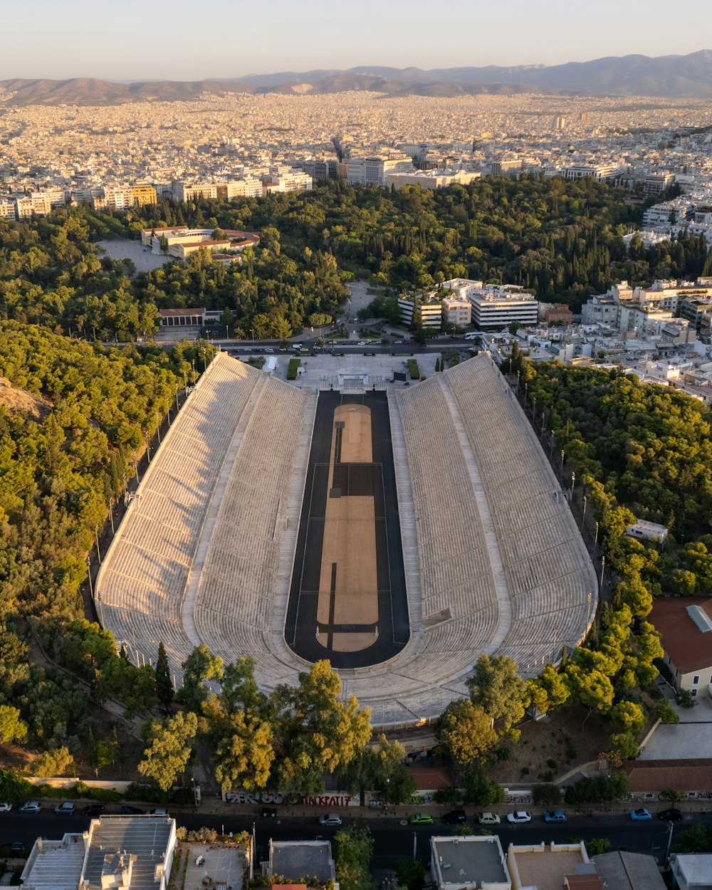 an aerial view of a stadium with trees surrounding it